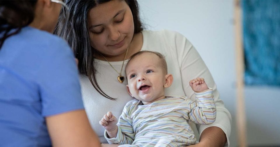 Mother Holding Child For Vaccine Shot